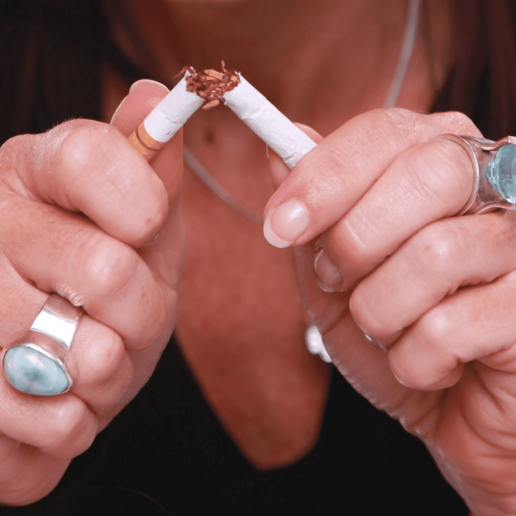 Zerbrochene Zigarette in Händen.
