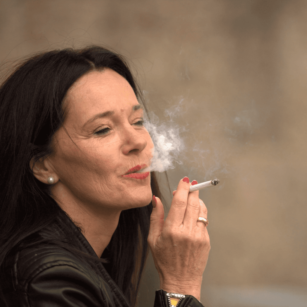 Frau raucht Zigarette im Freien.