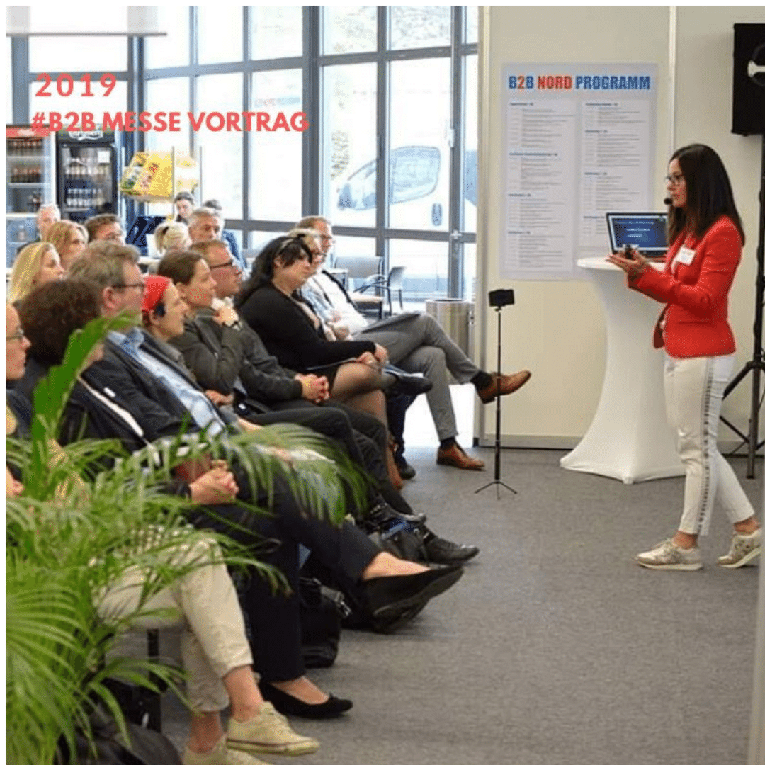 Referentin präsentiert vor Messepublikum.