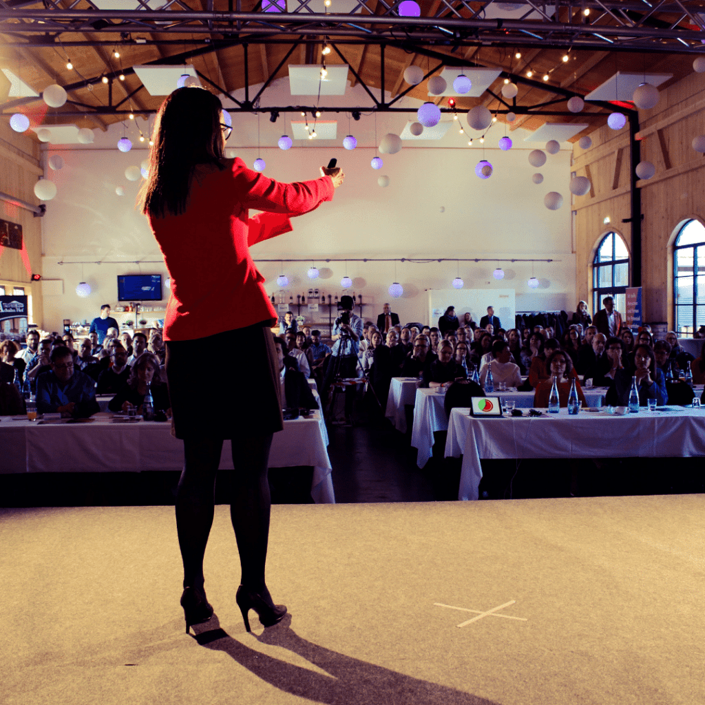 Rednerin präsentiert vor Konferenzpublikum.