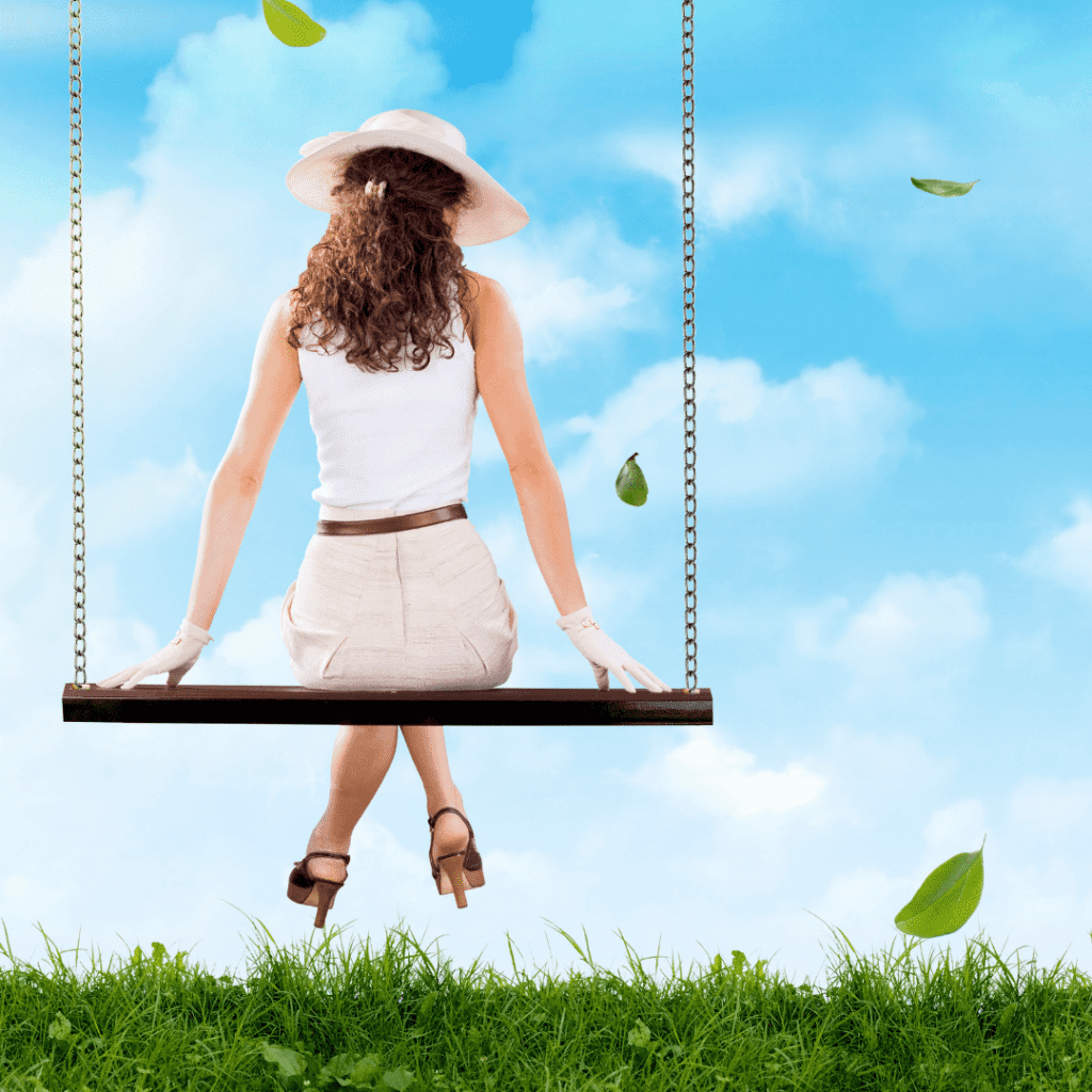 Frau sitzt auf Schaukel, Blick zum Himmel.