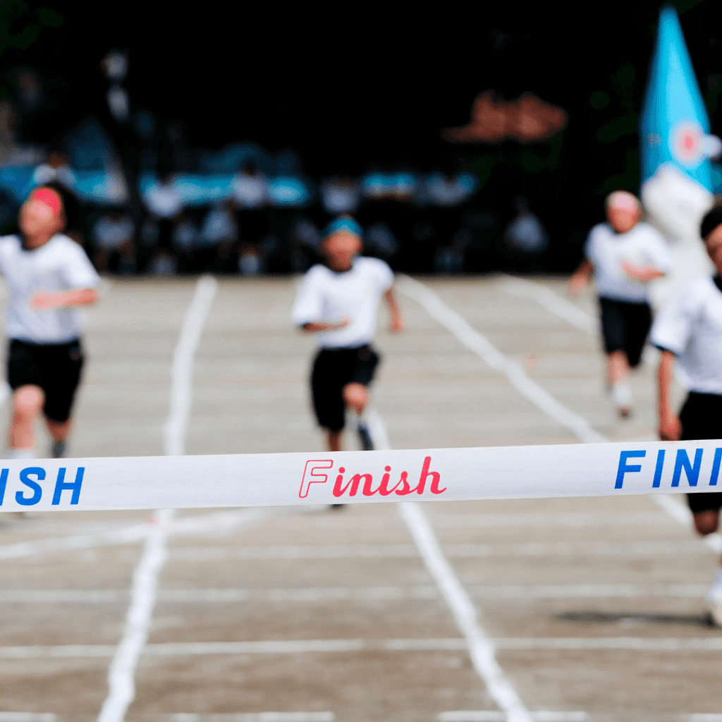 Kinder laufen zum Ziel bei Sportveranstaltung.