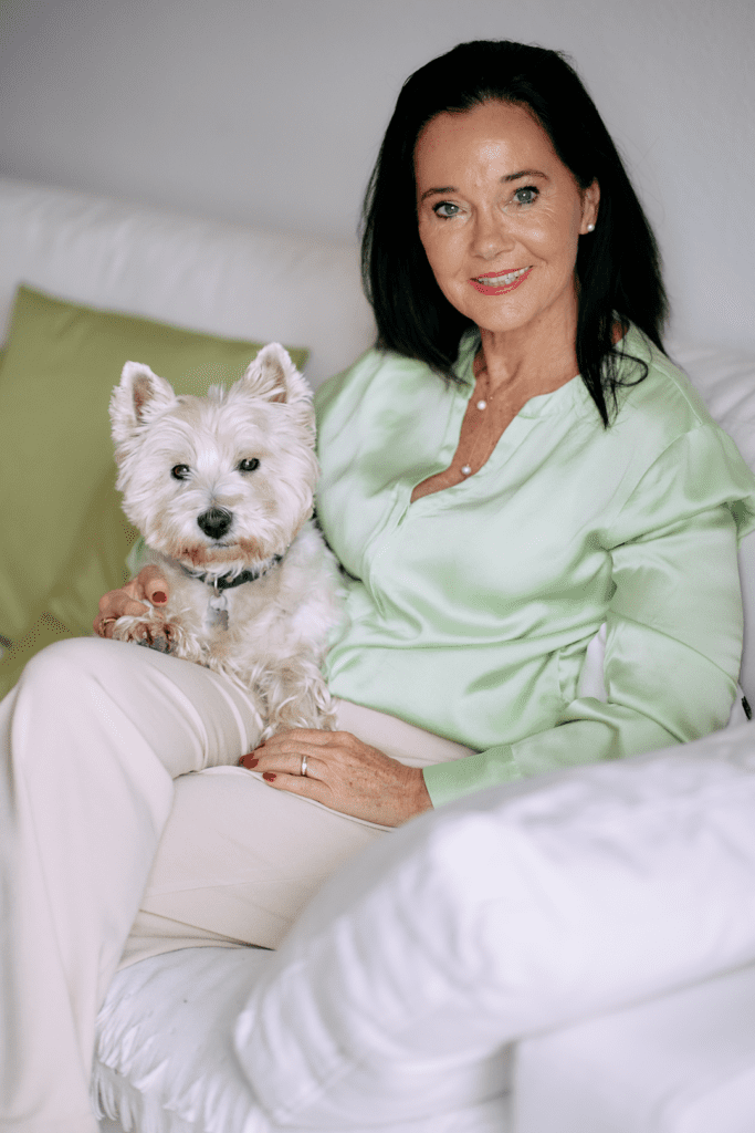 Frau mit West Highland Terrier auf Sofa