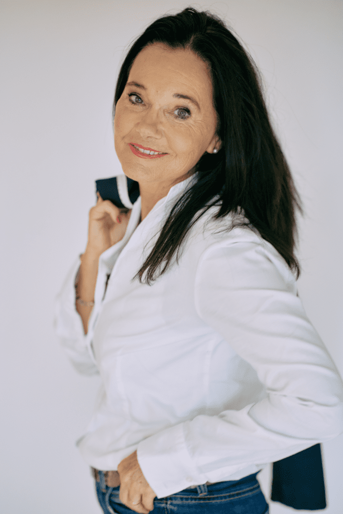 Lächelnde Frau in Weiß mit Blazer.